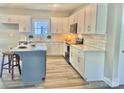Beautiful kitchen featuring white cabinets, a stylish island, stainless appliances, and modern countertops and backsplash at 325 Jordan Ave, Salisbury, NC 28159