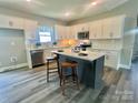 Bright kitchen with white cabinets, subway tile backsplash, stainless steel appliances, and center island with bar seating at 325 Jordan Ave, Salisbury, NC 28159