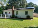View of a cozy one-story home with solar panels and a freshly mowed lawn on a sunny day at 327 Downing St, Troutman, NC 28166