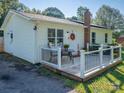 Side view of the house and cozy porch with a dining set on the well-maintained deck at 327 Downing St, Troutman, NC 28166