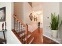 Inviting entryway with hardwood floors and a staircase with wooden and iron railings at 3537 Hornets Nest Way # 206, Charlotte, NC 28208
