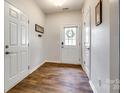 Inviting entryway with wood floors, white door with wreath, and neutral walls at 4107 Park South Station Blvd, Charlotte, NC 28210