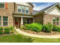 Welcoming home entrance with beautiful landscaping, a charming front door, and brick facade at 4220 Thames Cir, Fort Mill, SC 29715