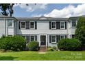 Well-maintained townhouse featuring black shutters, lush landscaping, and inviting entrance at 528 Wakefield Dr # A, Charlotte, NC 28209