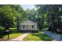 Charming home with well-maintained lawn, walkway, and mature trees providing ample shade at 616 Laurel St, Albemarle, NC 28001