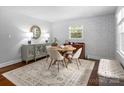 Sunlit dining room showcases a round table, four chairs, patterned wallpaper, and a large window with natural light at 6733 Candlewood Dr, Charlotte, NC 28210