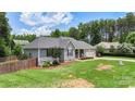Well-maintained single-story home with a manicured lawn, fenced yard, and an attached two-car garage at 7627 Sarah Dr, Denver, NC 28037