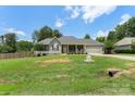 Well-maintained single-story home with a manicured lawn, fenced yard, and an attached two-car garage at 7627 Sarah Dr, Denver, NC 28037