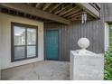 Condo entrance featuring a teal door, gray siding, and a concrete porch at 8135 Cedar Glen Dr, Charlotte, NC 28212