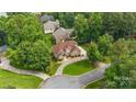 Beautiful brick home with lush landscaping, mature trees, and a circular driveway at 8918 Beach Bluff Ct, Sherrills Ford, NC 28673