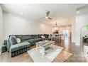 Bright and open living room with hardwood floors, ceiling fan, and view of the kitchen at 11546 Red Rust Ln, Charlotte, NC 28277