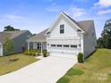 Well-maintained home with an attached two-car garage with a concrete driveway and green lawn at 117 Carmine Ct, Troutman, NC 28166