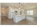 Open kitchen features white cabinets, an island with a sink, pendant lighting, and stainless steel appliances at 1266 Langston Ln, Salisbury, NC 28144