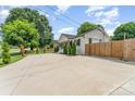 Spacious home featuring a large driveway, lush lawn, mature trees, and a wood privacy fence at 157 Downey Lake Rd, Dallas, NC 28034