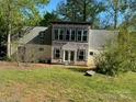 View of the home's rear elevation, highlighted by many windows and a serene backyard setting at 177 Mountain View Ln, Troy, NC 27371