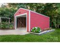 Exterior view of the red garage, featuring a flowerbed, concrete driveway, and an open garage door at 2115 Arnold Dr, Charlotte, NC 28205