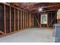 Interior view of the garage with a newly epoxied floor and unfinished walls with a window at 2115 Arnold Dr, Charlotte, NC 28205