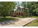 A two-story home displays its green exterior, complemented by a concrete driveway at 215 W Eastway Drive Dr, Charlotte, NC 28213