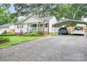 Driveway leading to a white single-story house with a front porch and metal carport at 2279 Cedar Oak Cir, Gastonia, NC 28052