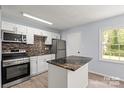 Modern kitchen featuring stainless steel appliances, a stylish backsplash, and a convenient center island at 2515 Danforth Ln, Charlotte, NC 28208