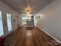Open living room with hardwood floors flowing into a bright kitchen with white cabinets and a kitchen island at 333 Mount View Ln # 266 B, New London, NC 28127
