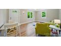 Bright living room featuring hardwood floors, large windows, and fresh paint with a white front door at 407 Cummings St, Rock Hill, SC 29730