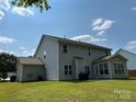 Large, grassy backyard with a patio area and an enclosed sunroom attached to this two-story home at 5009 Brook Valley Run, Monroe, NC 28110