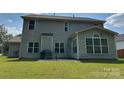 Spacious backyard with a patio, grill, seating, and a sunroom addition, ideal for outdoor gatherings at 5009 Brook Valley Run, Monroe, NC 28110