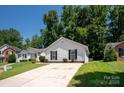 Inviting single-story home with a spacious driveway and a beautifully landscaped front yard at 5717 Fairchase Ave, Charlotte, NC 28269