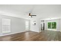 Bright and airy living room featuring hardwood floors, a ceiling fan, and sliding doors to the backyard at 5717 Fairchase Ave, Charlotte, NC 28269
