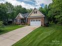 Beautiful brick home featuring a long driveway and a well-manicured lawn at 7988 Golf Course N Dr, Denver, NC 28037