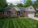 Attractive brick home featuring a well-manicured lawn and a two-car garage at 7988 Golf Course N Dr, Denver, NC 28037