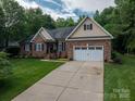 Beautiful brick home featuring a long driveway and a lush green lawn at 7988 Golf Course N Dr, Denver, NC 28037