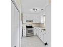 Well-lit kitchen featuring white cabinets, stainless steel oven, tile floor and an adjacent refrigerator space at 10016 Heathergate Ln, Mint Hill, NC 28227