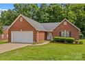 Charming one-story brick home with an attached garage, manicured lawn, and lush landscaping at 103 Prestwick Ct, Salisbury, NC 28146