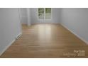 Bright, empty bedroom with hardwood floors, white walls, trim and plenty of natural light through a large window at 10931 Osprey Dr, Charlotte, NC 28226