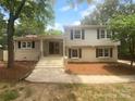 Charming two-story home features a brick and gray facade, welcoming entrance, and landscaped front yard at 10931 Osprey Dr, Charlotte, NC 28226