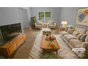 Bright, staged living room with large window, hardwood floors, stylish furniture, and an inviting, warm ambiance at 10931 Osprey Dr, Charlotte, NC 28226