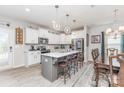 Modern kitchen features an island with bar stool seating, stainless steel appliances, and white cabinetry at 1117 Laurel Woods Dr, Gastonia, NC 28052