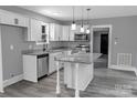 Bright kitchen with white cabinets, granite countertops, island with pendant lights, and stainless steel appliances at 1210 Cloninger Ave, Gastonia, NC 28052