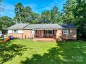 Brick home with covered front porch, offering curb appeal and a welcoming entrance at 12143 Asbury Chapel Rd, Huntersville, NC 28078