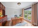 Bright home office featuring wood floors, built in cabinet, large window, and wood desk at 184 Melbourne Dr, Fort Mill, SC 29708