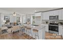 Well-lit kitchen featuring an island with barstool seating, stainless steel appliances, and white cabinetry at 207 Putnam St, Shelby, NC 28152