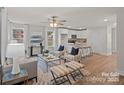 Open-concept living room with hardwood floors, plush seating, and lots of natural light from large windows at 207 Putnam St, Shelby, NC 28152