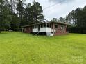 View of a brick home with a screened-in porch and a lush green lawn area at 2350 Grubb Ferry Rd, Salisbury, NC 28144