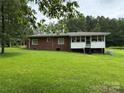 Brick home featuring a screened-in porch, green lawn, and backyard at 2350 Grubb Ferry Rd, Salisbury, NC 28144