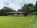 Classic brick home with a covered front porch, carport, and a well-maintained lawn area at 2350 Grubb Ferry Rd, Salisbury, NC 28144