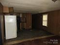 Living Room and partial kitchen with wood walls and worn carpet at 2927 S Nc 16 Hwy, Newton, NC 28658
