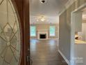 View of a large living room with a fireplace, hardwood floors, and two windows at 4402 Poxon Ln, Monroe, NC 28110