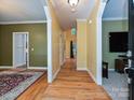 Bright hallway with hardwood floors and white trim, leading to various rooms in the home at 443 Hillcrest Dr, Harrisburg, NC 28075